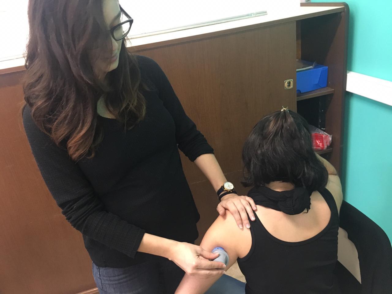 Previo a un ensayo, la ingeniera Emilia Fushimi aplicando un sensor a una compañera de trabajo para hacer pruebas de conectividad